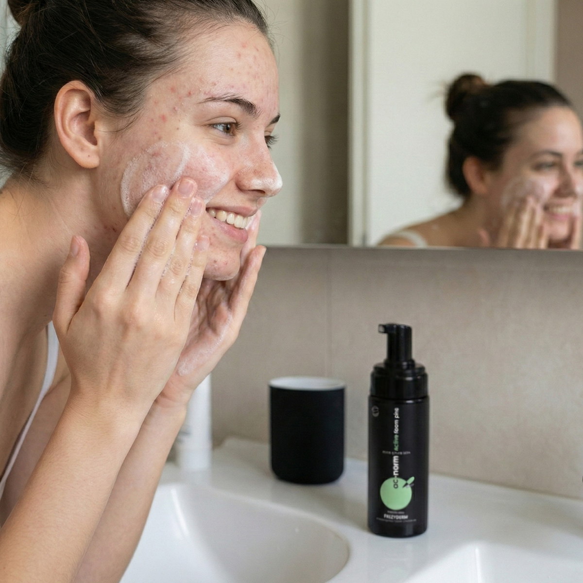 Woman cleansing her face with FREZYDERM AC-Norm Active Foam Plus