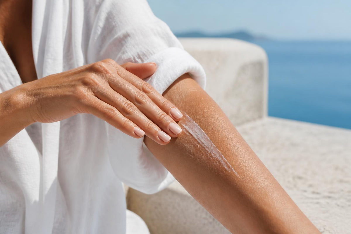 Applying sunscreen to an arm beside the sea