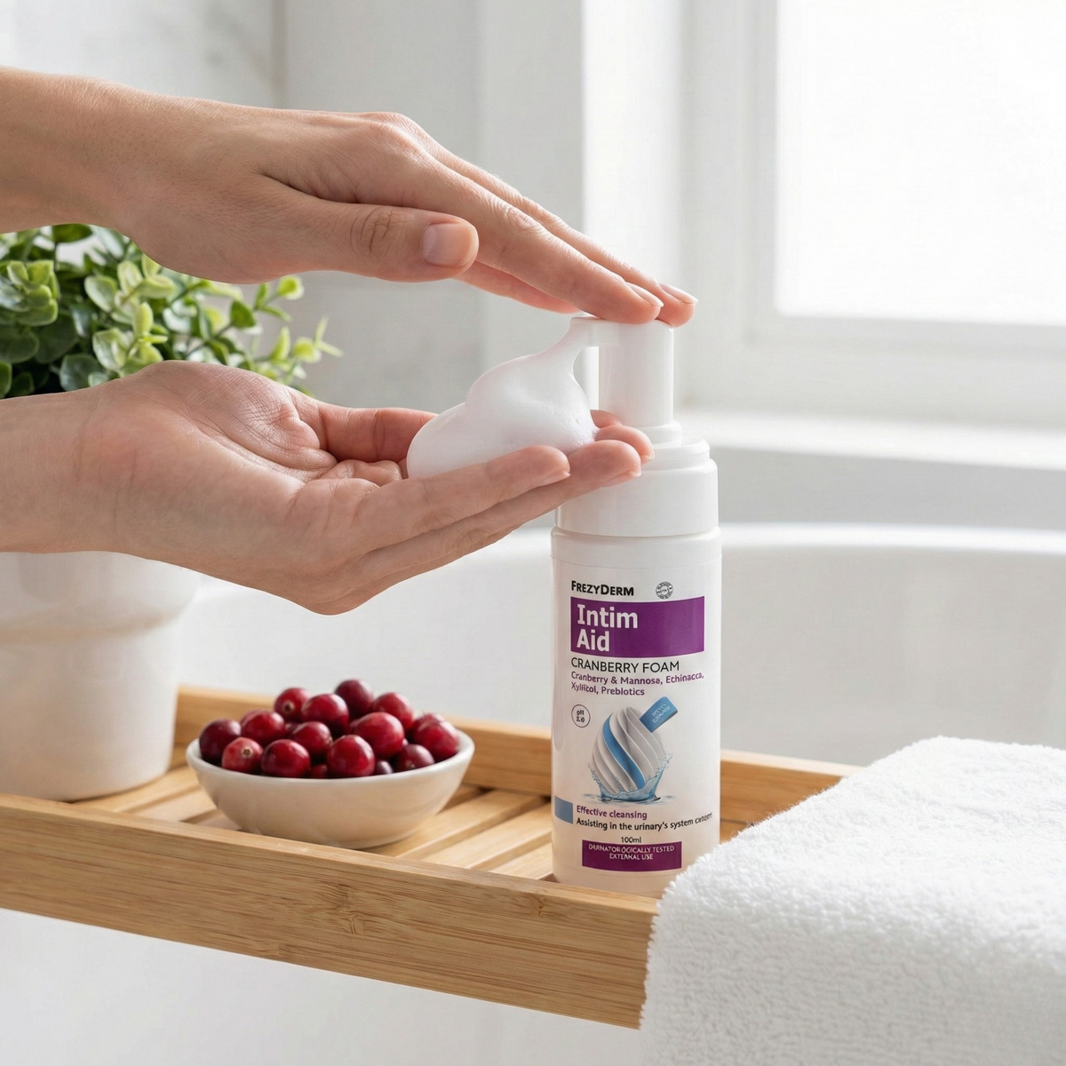 FREZYDERM Intim Aid Cranberry Foam being dispensed into a hand