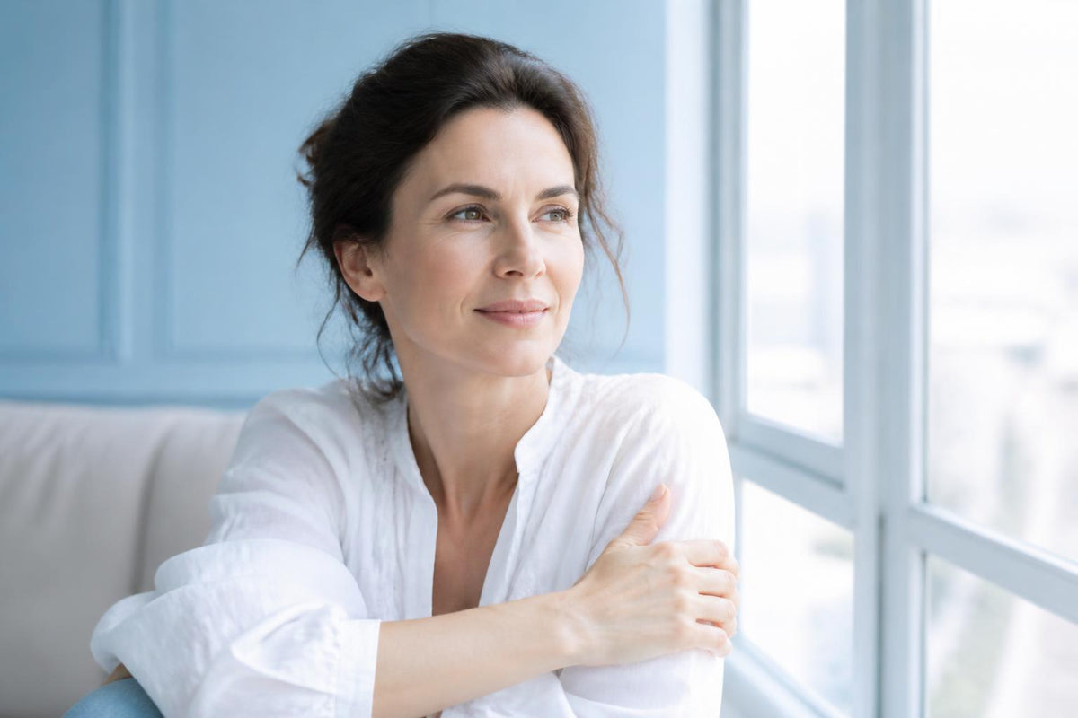 Woman enjoying a quiet moment beside a window